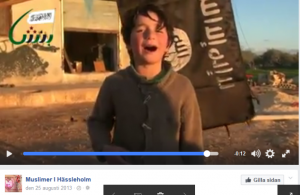 Pojken sjugner med IS-flaggan vajande i bakgrunden
