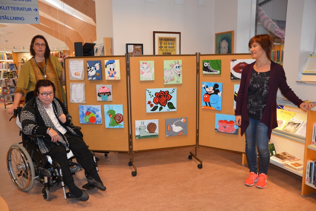 Ekelidens målargrupp ställer ut på biblioteket i Tyringe, från vänster konstnärerna Lotta Nilsson och Anette Öhman och Kristina Svensson i personalen. Foto: Berit Önell