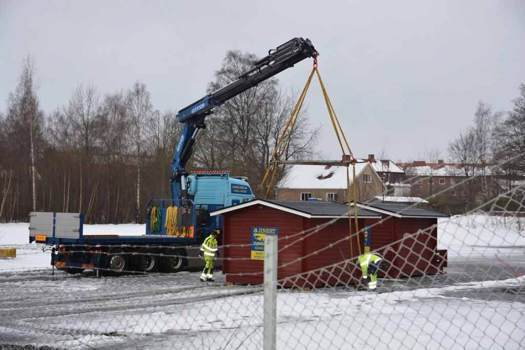 Några av de före detta valstugorna lyftes på tisdagseftermiddagen fram ur förrådsbyggnaden vid InMente för vidare transport till Stortorget inför julskyltningen. Bygglov är sökt för uppställning av fem stugor för EU-migranter i nöd på InMentes mark. Foto: Berit Önell