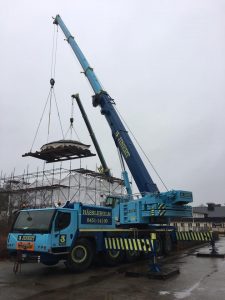 Två stora kranar från Jinerts lyfte paviljongens tak på plats på det nya fundamentet inne i "tältet".