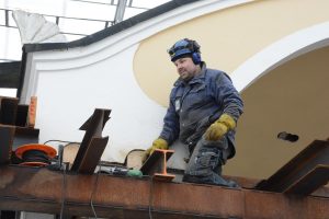 Magnus Åkesson arbetar med att montera ned bit för bit av stålkonstruktionen och svetsa fast paviljongens tak i pelarna.