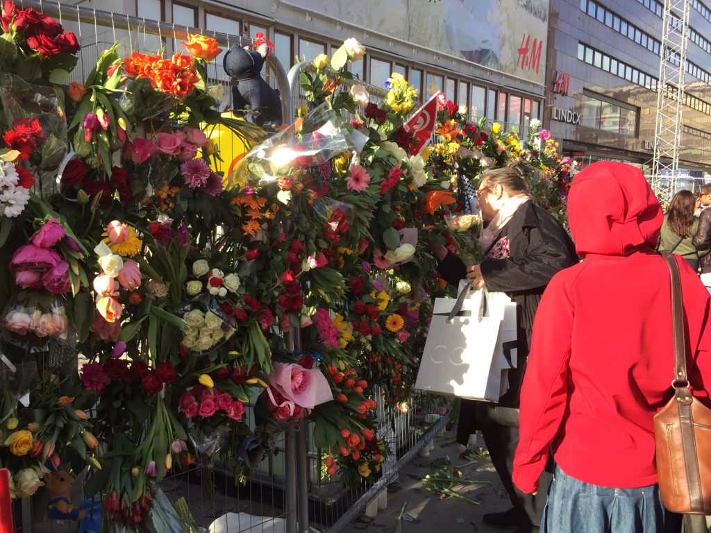 Människor fortsatte sent på eftermiddagen att fästa blommor i kravallstaketet vid Drottninggatan. Foto: Berit Önell