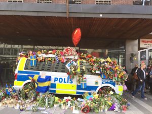 En polisbuss är dekorerad med blommor utanför Åhlens City. Foto. Berit Önell