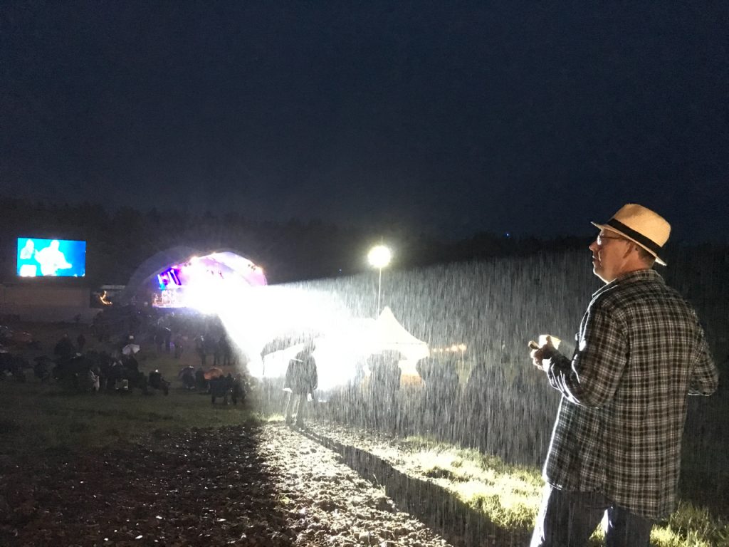 Regnet öste ner, men festivalgeneralen Mats Gunnarsson var inte bekymrad. Han njöt av en kopp kaffe i backen medan OnQ värmde upp publiken inför Sanne Salomonsens entré. Foto: Lotta Persson 