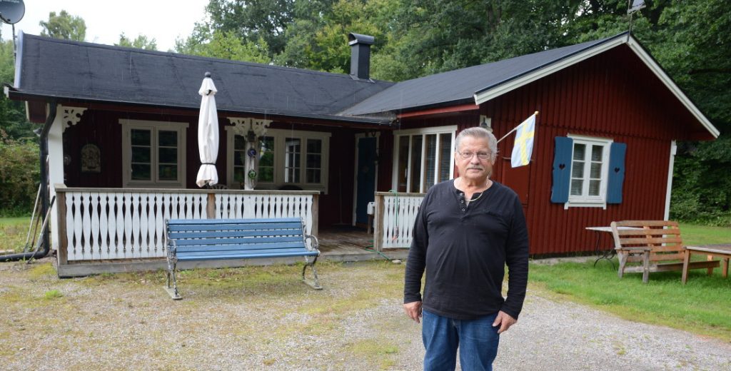 Bilden visar Jan Tillgren vid sitt hus.