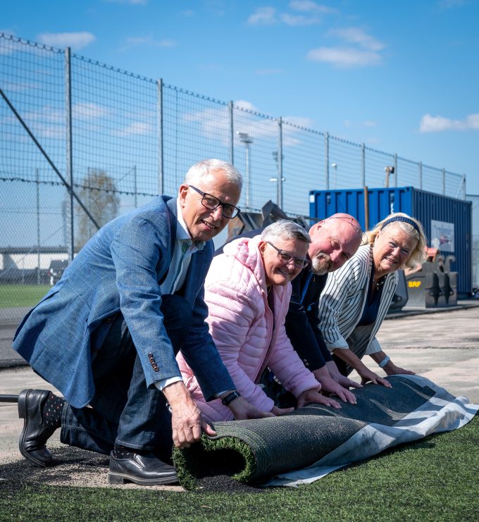 Sven Olof Bernhoff VD Skånefrö, Connie Asterman (S), Paul Thurn (SD) och Margreth Segerstein (M) från Kultur- och Fritidsnämnden rullar gemensamt upp gräsmattan på Österås IP – ett annorlunda första spadtag. Foto: Thomas Bengtsson, Fri Kommunikation