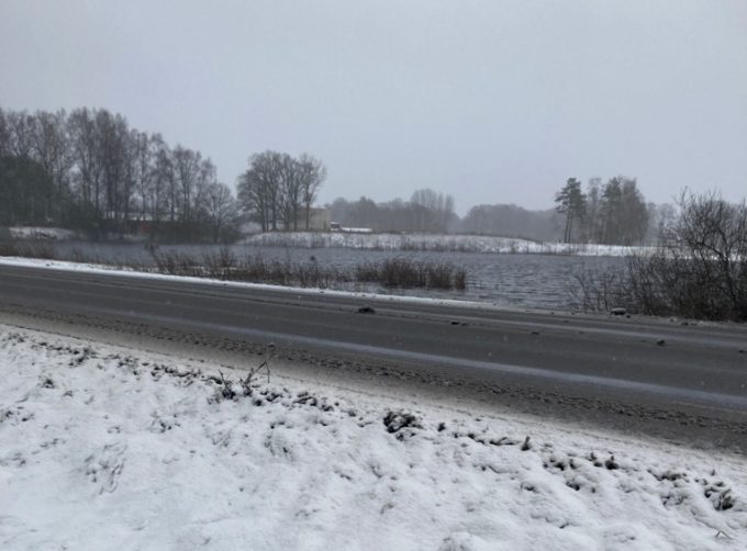 Bilden visar översvämmade åkrar med reningsverket i bakgrunden.