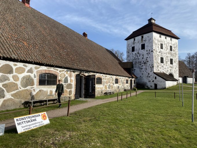 Bilden visar Zidi Holster vid Hovdala slott med informationsskylt i förgrunden.