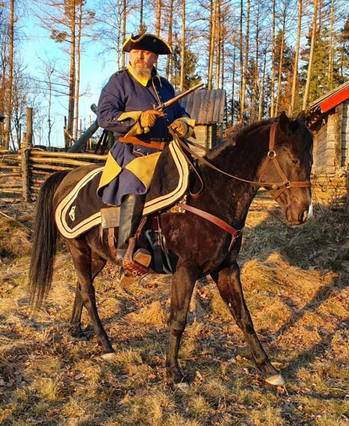 Bilden visar Oddvar Lönnerkrantz till häst med karolineruniform och flintlåspistol.